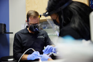 Hilliard dentist Dr. Phil Chahine performing periodontal disease treatment on a Columbus patient sore, inflamed gums.