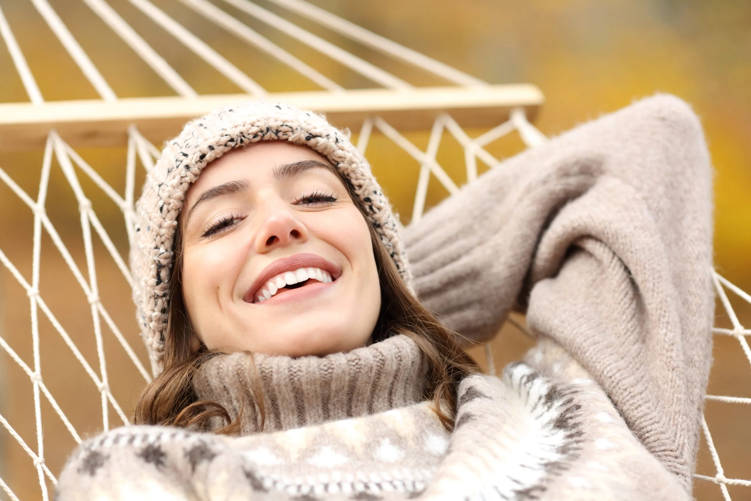 happy woman smiling on hammock, perfect teeth