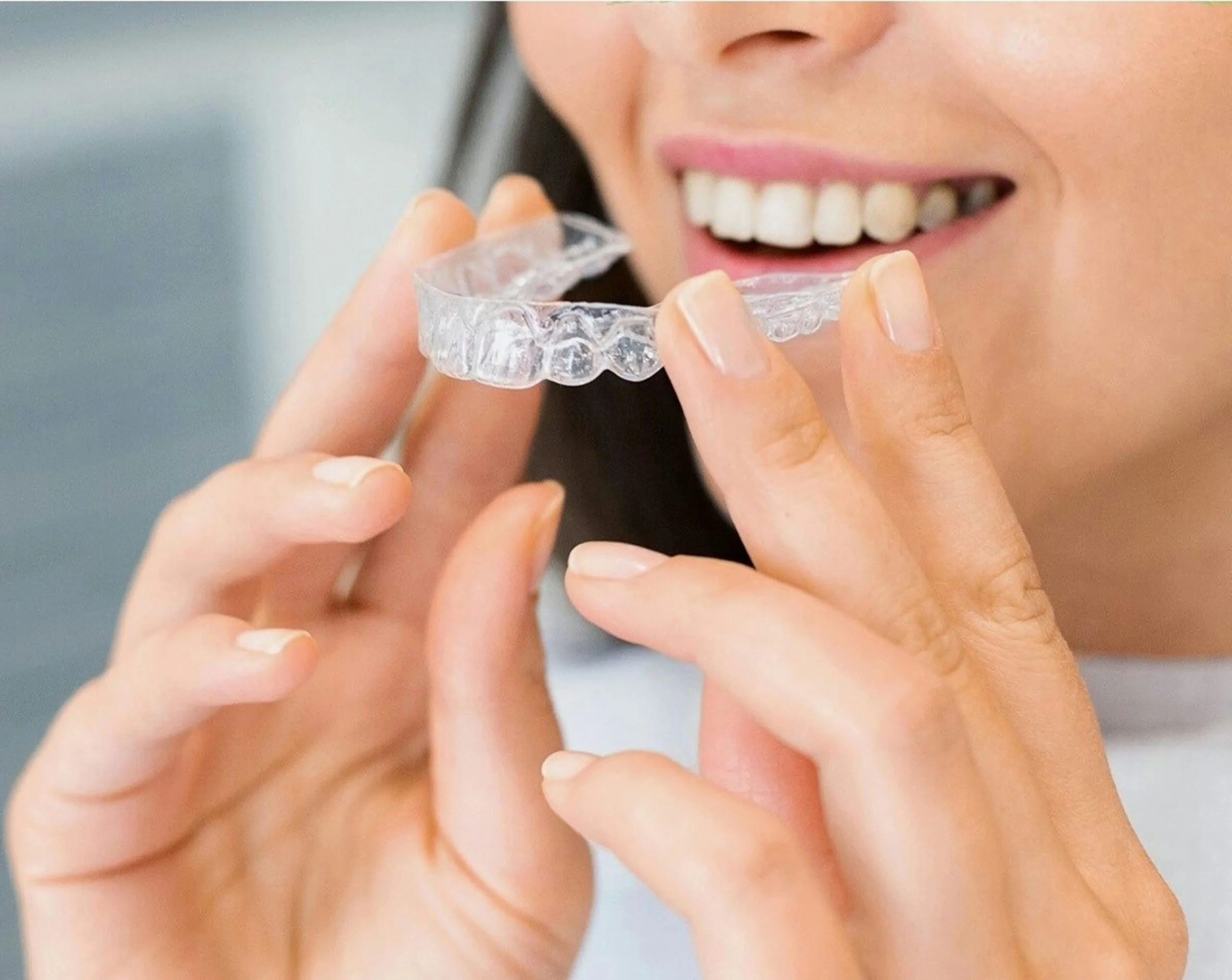 columbus woman holding invisalign clear braces at dentist office in Hilliard
