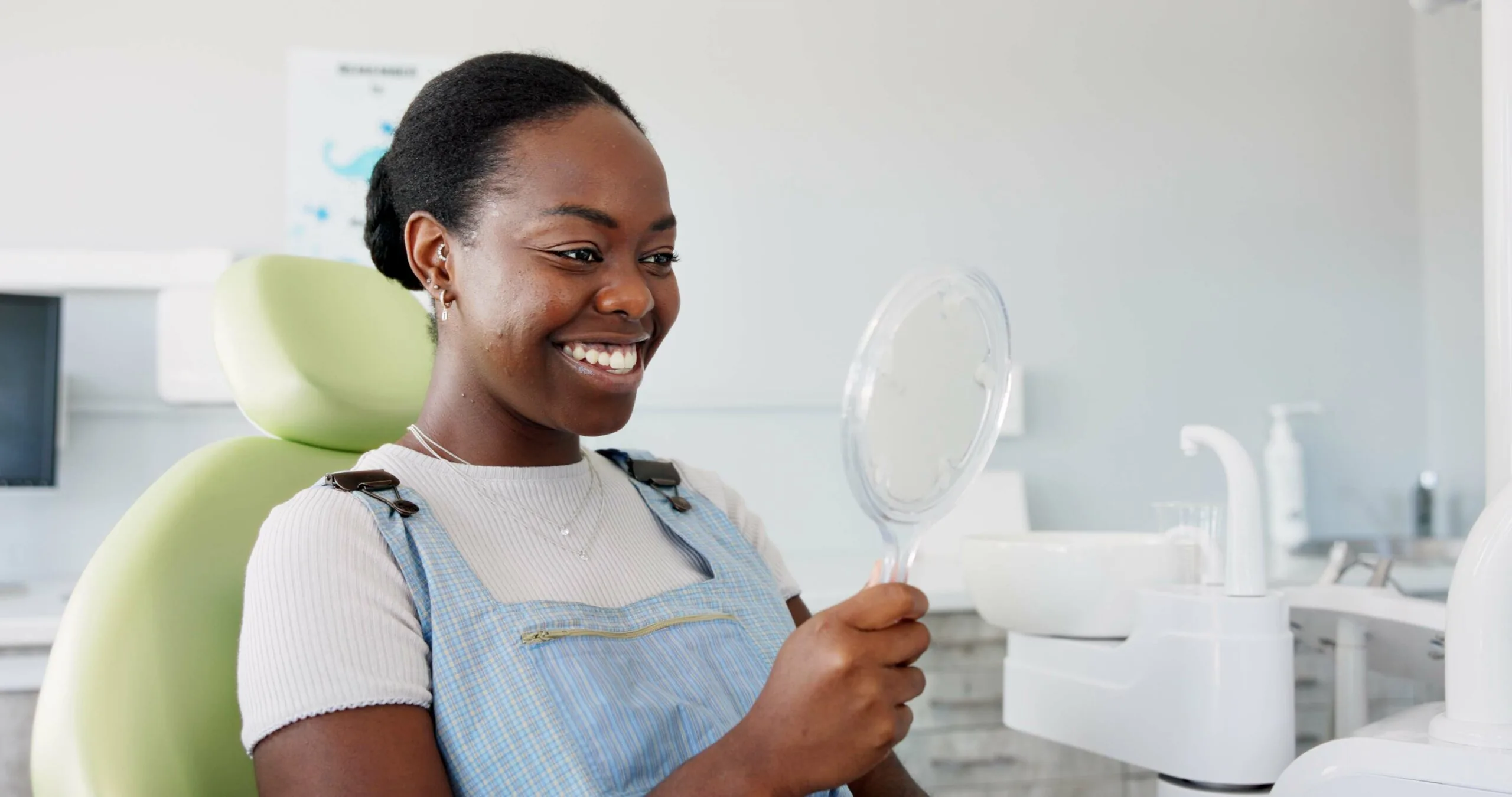 happy woman looking in a mirror, new teeth whitening treatment